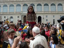Pope Francis greets children in the San Damaso Courtyard during the puppet Little Amal’s visit to the Vatican, Sept. 10, 2021.